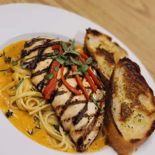 a plate of pasta and grilled chicken