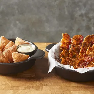 a plate of pizza and a bowl of dipping sauce