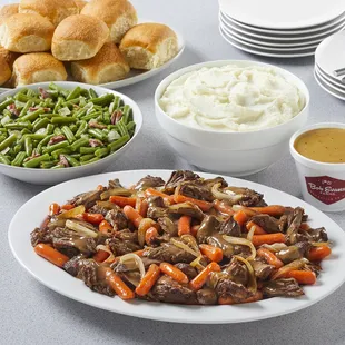 a plate of beef, carrots, green beans, and mashed potatoes