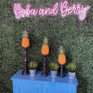 three pineapples on a blue sideboard