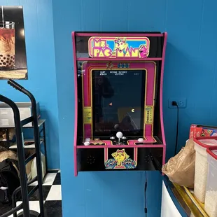 a pink arcade machine in a blue room