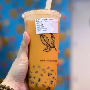 a hand holding a cup of bubble tea