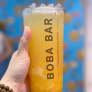 a person holding a glass of boba