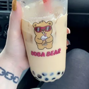 a hand holding a cup of boba bear