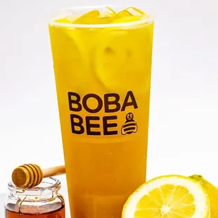 a glass of boba bee with a lemon and honey