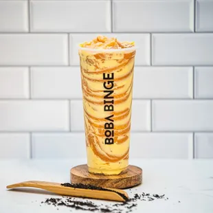 a glass of boba binge with a wooden spoon