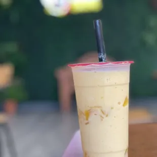Peach smoothie with peach toppings inside.
