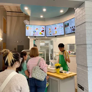 a woman ordering food from a counter