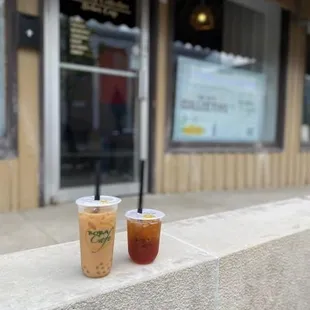 two cups of iced coffee on a ledge