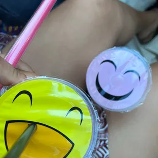 a person holding a straw with a smiley face drawn on it