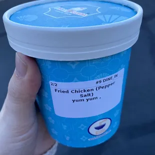 a person holding a cup of food