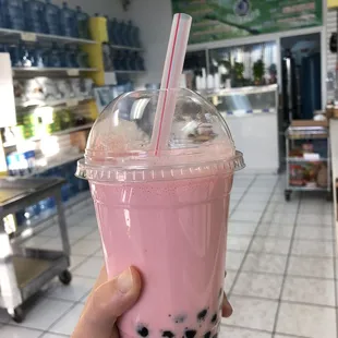 a hand holding a cup of bubble tea