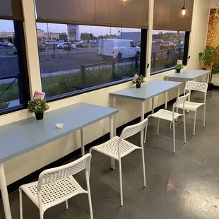 a row of blue tables and white chairs