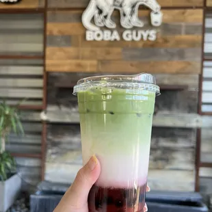 Large strawberry matcha latte with boba and light ice.