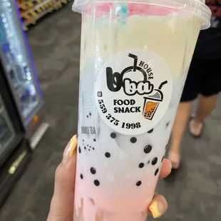 a hand holding a cup of boba