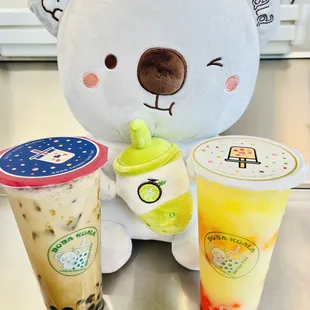 a white teddy bear and two drinks