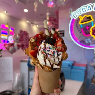 a hand holding a cone of ice cream