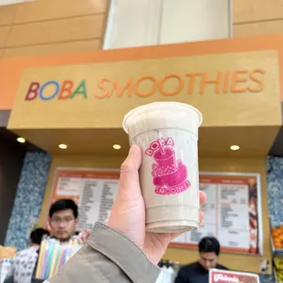 a hand holding a cup of boba smoothies