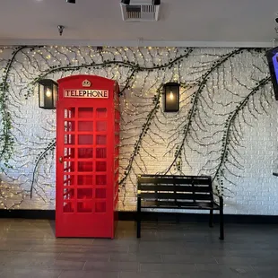 a red telephone booth and a bench