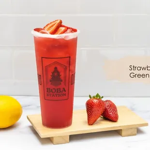 a glass of strawberry green tea with strawberries