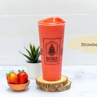 strawberries in a cup next to a strawberries bush