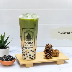 a glass of boba milk tea and a pine cone