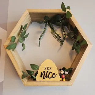 a shelf with a bee nice sign