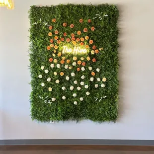 a moss wall with orange and white flowers
