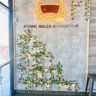 a wall with a sign that says along smiles in every cup