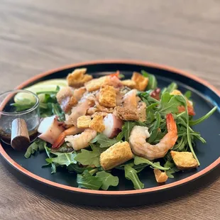 a salad with shrimp and croutons
