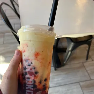 a hand holding a cup of boba