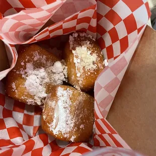 a basket of donuts with powdered sugar