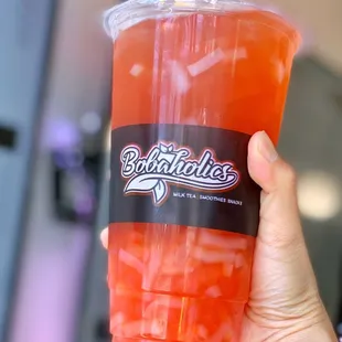 a hand holding a cup of juice