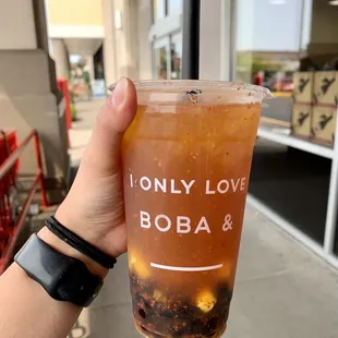 Mango black tea with mango bits, boba, and tajin