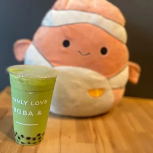 a cup of bubble tea next to a plush toy