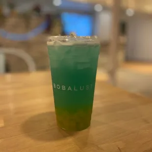 a green drink in a plastic cup