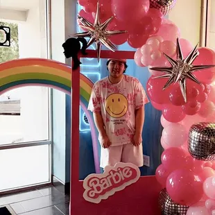 a man standing in front of a balloon arch