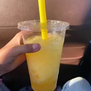 a person holding a plastic cup with a yellow straw