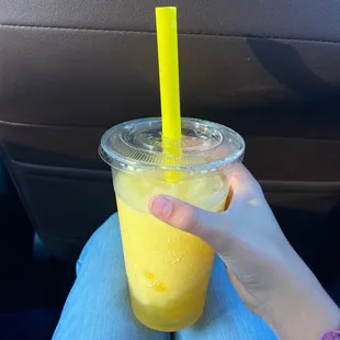 a person holding a plastic cup with a straw