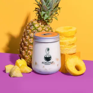 a pineapple next to a jar of yogurt