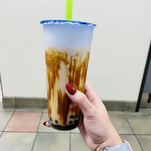 a hand holding a cup of iced coffee