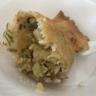 Vegetable samosa (half eaten).