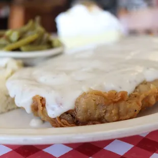 a plate of fried chicken with gravy and mashed potatoes