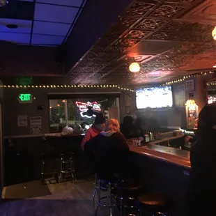 a bar with people sitting at the bar