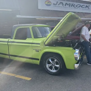 a green pick up truck with its hood open
