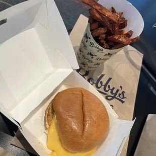 Grilled chicken sandwich with cheese, pickles and bacon and crispy sweet potato fries.