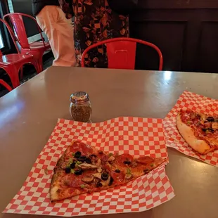 Supreme Pizza Slices and indoor seating