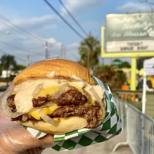 a hand holding a hamburger