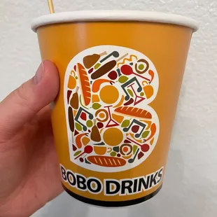 a hand holding a paper cup
