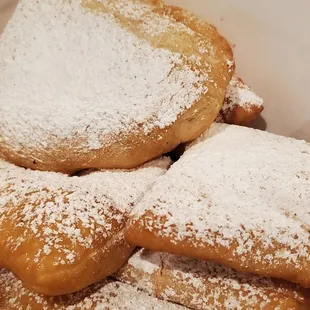 powdered sugared donuts in a paper bag